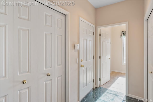 17601 Rolling Woods Cir, Northville, MI 48168 - hall featuring dark tile patterned flooring and baseboards
