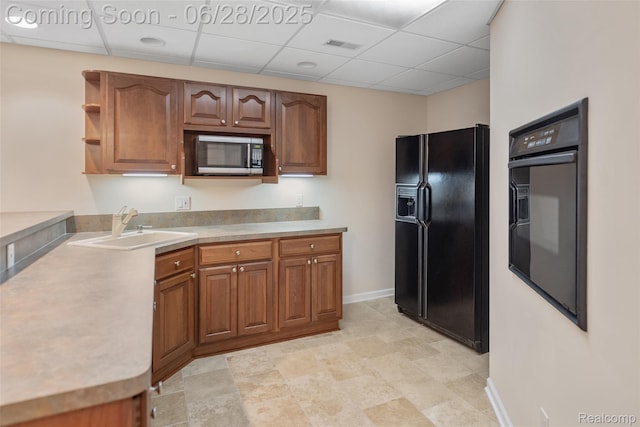 17601 Rolling Woods Cir, Northville, MI 48168 - kitchen featuring black appliances, brown cabinets, light countertops, a paneled ceiling, and open shelves