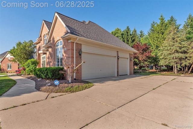 17601 Rolling Woods Cir, Northville, MI 48168 - view of side of property with brick siding, an attached garage, driveway, and a shingled roof