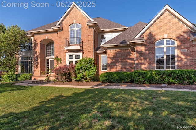 17601 Rolling Woods Cir, Northville, MI 48168 - traditional-style home with brick siding, a front yard, a balcony, and a shingled roof