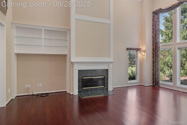 17601 Rolling Woods Cir, Northville, MI 48168 - unfurnished living room with a high ceiling, hardwood / wood-style flooring, and a fireplace