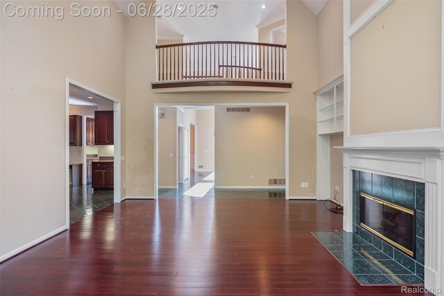 17601 Rolling Woods Cir, Northville, MI 48168 - unfurnished living room with a high ceiling, a fireplace, and wood finished floors