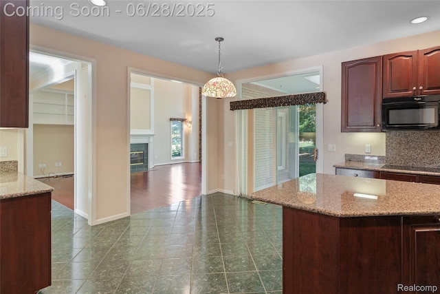 17601 Rolling Woods Cir, Northville, MI 48168 - kitchen with black appliances, healthy amount of natural light, hanging light fixtures, a glass covered fireplace, and recessed lighting