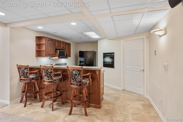 17601 Rolling Woods Cir, Northville, MI 48168 - kitchen with stainless steel microwave, black refrigerator with ice dispenser, open shelves, light countertops, and a peninsula