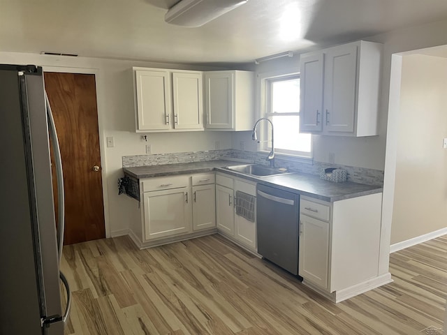 4704 Bishop St, Millington, MI 48746 - kitchen with appliances with stainless steel finishes, light wood finished floors, and white cabinetry