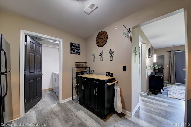 2635 Greenstone Blvd Unit 508, Auburn Hills, MI 48326 - bar area featuring freestanding refrigerator, light wood finished floors, and washer and clothes dryer