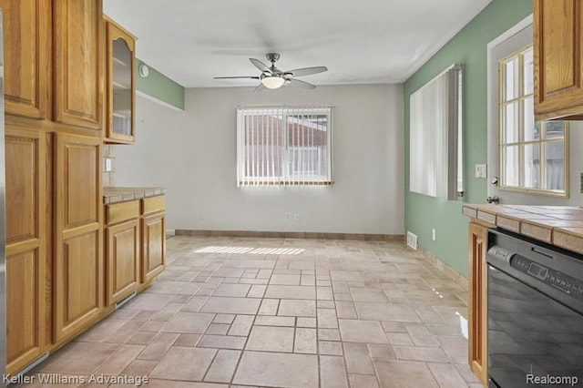 274 Beaver St, Brighton, MI 48116 - kitchen with black dishwasher, tile counters, a ceiling fan, glass insert cabinets, and light stone finish floors