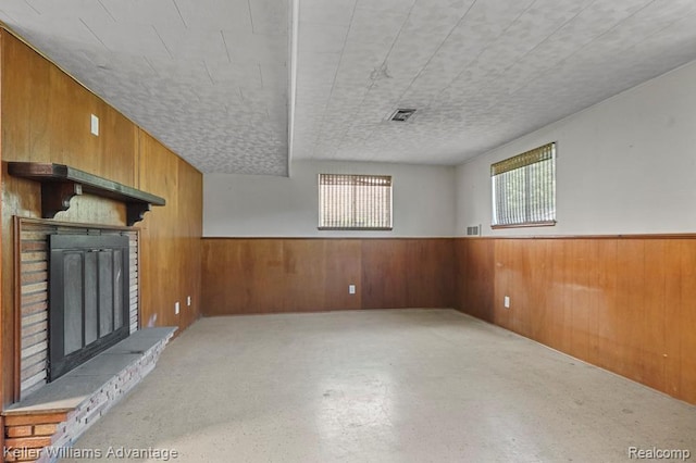 274 Beaver St, Brighton, MI 48116 - unfurnished living room featuring wood walls, a fireplace, and a wainscoted wall