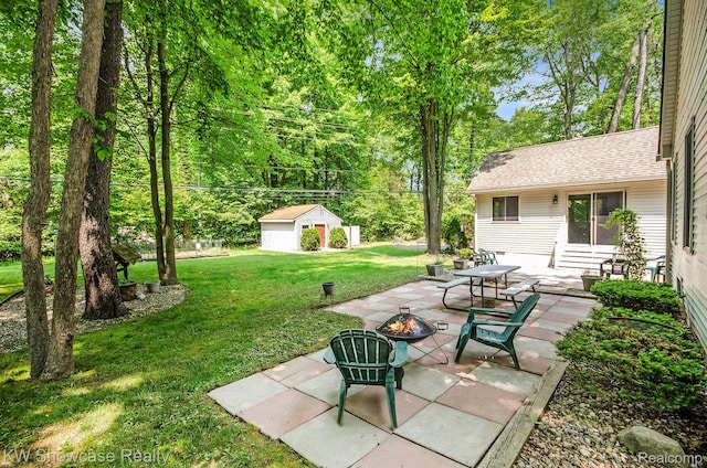 3675 S Commerce Rd, Commerce Twp, MI 48390 - view of grassy yard with a fire pit, a patio area, and an outbuilding