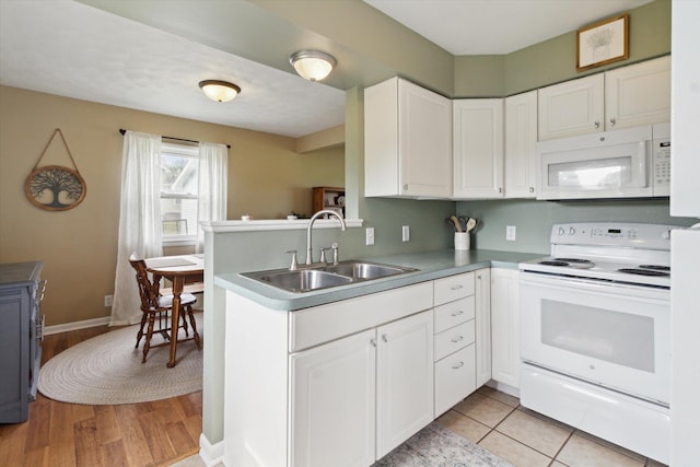 12350 S Butternut Ave, Sand Lake, MI 49343 - kitchen with white appliances, white cabinets, a peninsula, and light wood-style flooring