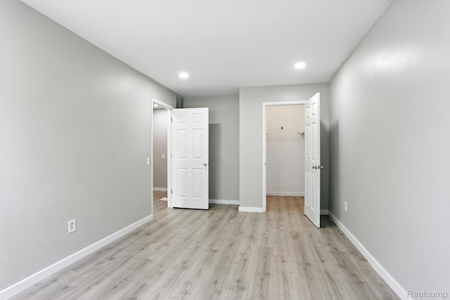 3043 Oakridge Ct, Lake Orion, MI 48360 - unfurnished bedroom with light wood-style flooring, recessed lighting, a spacious closet, and a closet