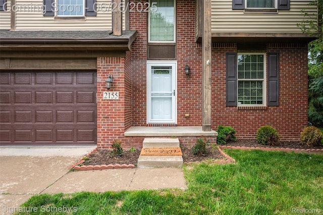 2155 Canal St, Commerce Twp, MI 48382 - view of exterior entry featuring brick siding, a garage, and driveway