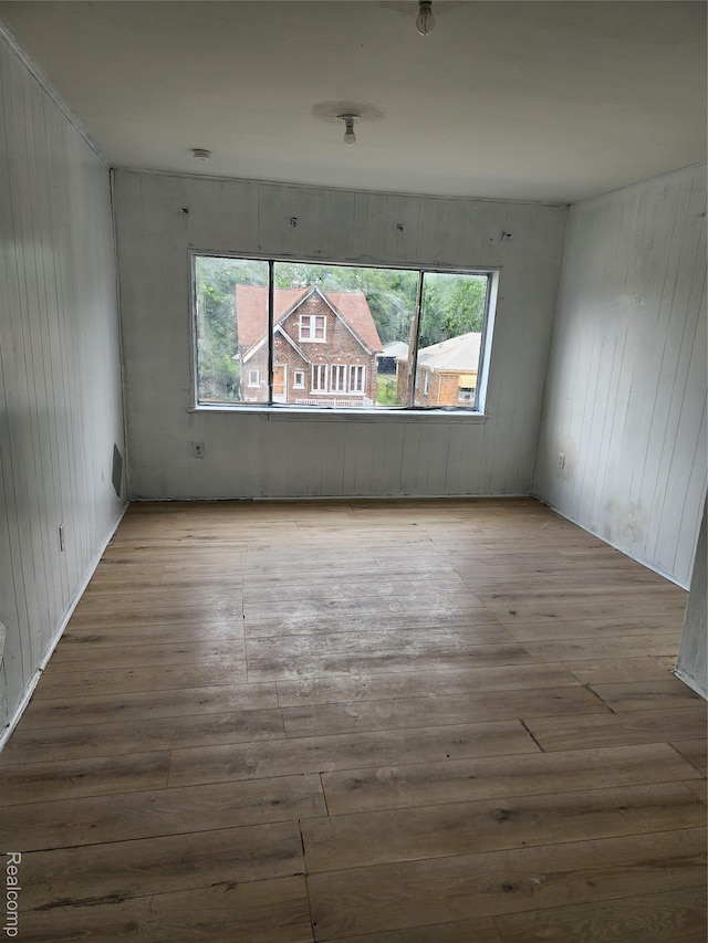 7458 E Quinn St, Detroit, MI 48234 - unfurnished room with hardwood / wood-style flooring, healthy amount of natural light, and wood walls