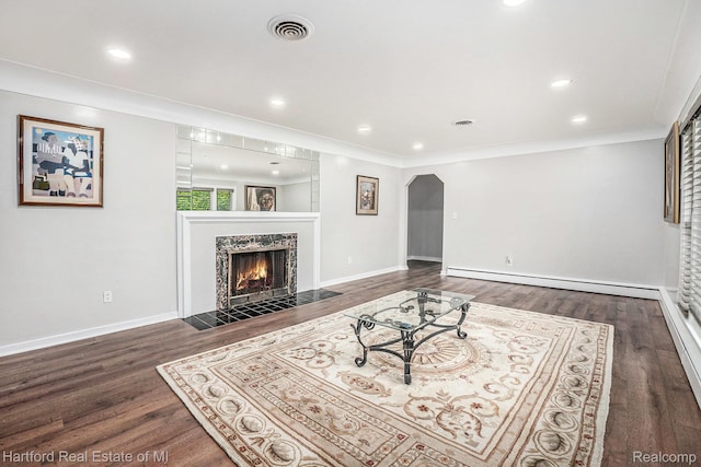 19100 Coral Gables St, Southfield, MI 48076 - living room featuring a baseboard radiator, a fireplace, wood finished floors, arched walkways, and recessed lighting