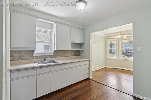 15848 Woodworth, Plymouth, MI 48239 - kitchen with dark wood-style floors, tasteful backsplash, light countertops, a chandelier, and white cabinets