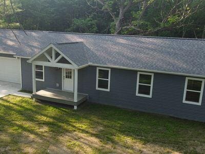 817 Sandow Rd, Midland, MI 48640 - view of front of property with a front lawn, concrete driveway, a garage, and roof with shingles
