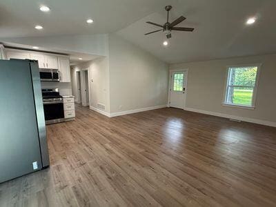 817 Sandow Rd, Midland, MI 48640 - unfurnished living room with a ceiling fan, vaulted ceiling, wood finished floors, and recessed lighting