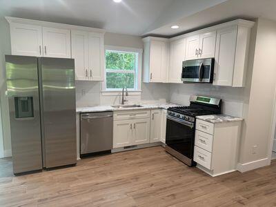 817 Sandow Rd, Midland, MI 48640 - kitchen featuring stainless steel appliances, light countertops, recessed lighting, white cabinetry, and light wood-type flooring