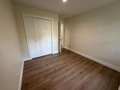 817 Sandow Rd, Midland, MI 48640 - unfurnished bedroom featuring wood finished floors and a closet