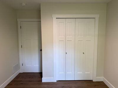 817 Sandow Rd, Midland, MI 48640 - unfurnished bedroom featuring dark wood-style floors and a closet