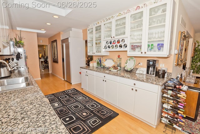3788 Crestlake Dr, Bloomfield Hills, MI 48304 - kitchen featuring white cabinetry, light wood finished floors, recessed lighting, glass insert cabinets, and light stone countertops