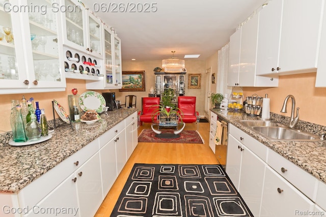 3788 Crestlake Dr, Bloomfield Hills, MI 48304 - kitchen with white cabinetry, light wood-style flooring, and a chandelier