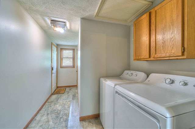 123 Carlysle Dr, Brooklyn, MI 49230 - laundry room with washer and clothes dryer, cabinet space, a textured ceiling, light wood-style flooring, and attic access