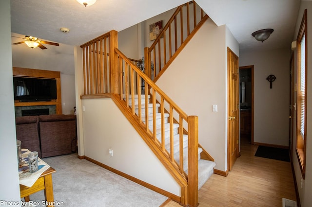 17474 Connor Cir, Bailey, MI 49303 - stairs featuring ceiling fan and a fireplace