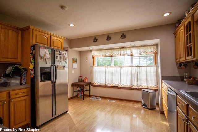 17474 Connor Cir, Bailey, MI 49303 - kitchen featuring appliances with stainless steel finishes, brown cabinets, glass insert cabinets, light wood-style floors, and recessed lighting