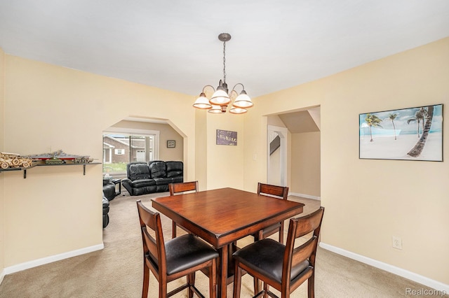 701 Cleophus Pkwy, Lincoln Park, MI 48146 - dining space featuring light colored carpet, arched walkways, and a chandelier