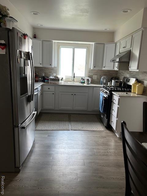 20796 Gill Rd, Farmington Hills, MI 48335 - kitchen with appliances with stainless steel finishes, under cabinet range hood, decorative backsplash, light countertops, and recessed lighting