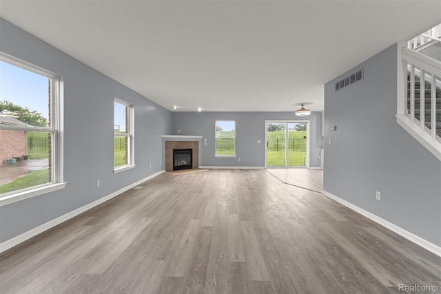 10913 Edlie Cir, Dearborn Heights, MI 48214 - unfurnished living room featuring wood finished floors, a tiled fireplace, and stairway