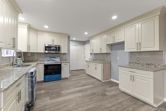 10913 Edlie Cir, Dearborn Heights, MI 48214 - kitchen featuring stainless steel appliances, recessed lighting, decorative backsplash, light wood-style floors, and light stone counters