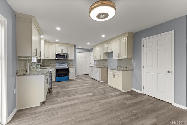 10913 Edlie Cir, Dearborn Heights, MI 48214 - kitchen featuring appliances with stainless steel finishes, light wood-style floors, recessed lighting, light stone countertops, and backsplash