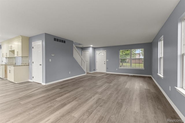 10913 Edlie Cir, Dearborn Heights, MI 48214 - unfurnished living room featuring stairway and light wood finished floors