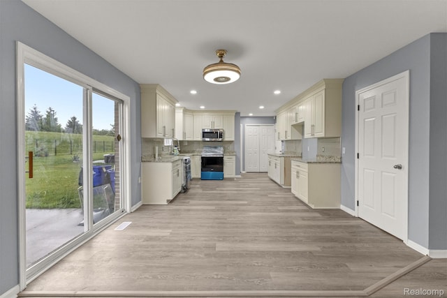 10913 Edlie Cir, Dearborn Heights, MI 48214 - kitchen featuring appliances with stainless steel finishes, light wood-style floors, light stone counters, and recessed lighting