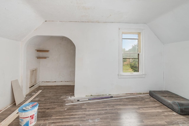 735 W Stewart St, Owosso, MI 48867 - additional living space with lofted ceiling, wood finished floors, and arched walkways