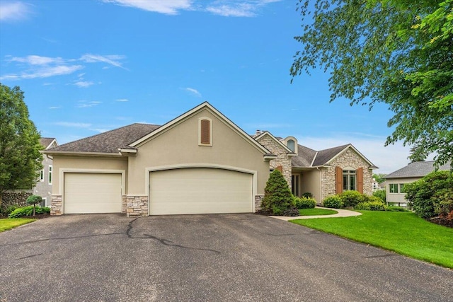 7870 Mooring Ct, Hudsonville, MI 49426 - view of front of house with stone siding, stucco siding, an attached garage, and driveway