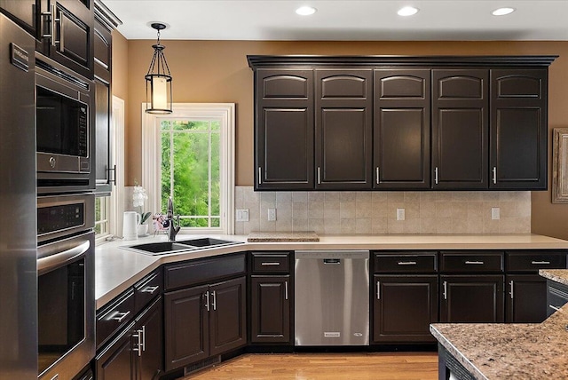 7870 Mooring Ct, Hudsonville, MI 49426 - kitchen with appliances with stainless steel finishes, hanging light fixtures, light wood-type flooring, recessed lighting, and decorative backsplash