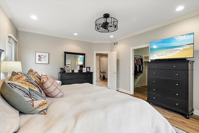 7870 Mooring Ct, Hudsonville, MI 49426 - bedroom featuring wood finished floors, a spacious closet, crown molding, recessed lighting, and a closet