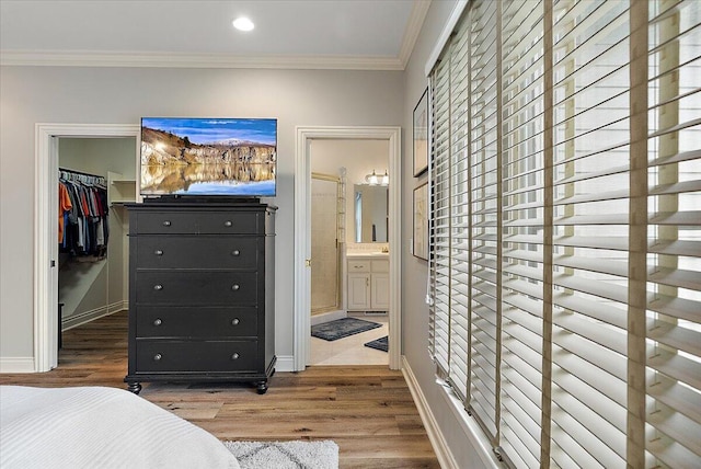 7870 Mooring Ct, Hudsonville, MI 49426 - bedroom featuring a spacious closet, wood finished floors, a closet, ornamental molding, and ensuite bath