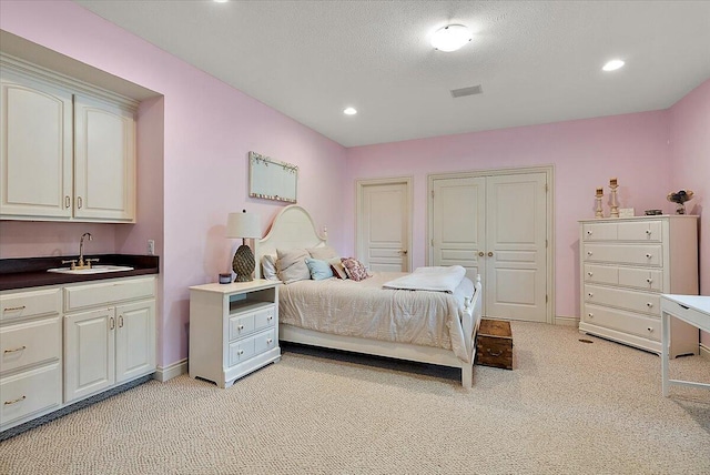 7870 Mooring Ct, Hudsonville, MI 49426 - bedroom with light carpet, multiple closets, recessed lighting, and a textured ceiling