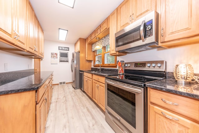 1169 Wilbur, Pinckney, MI 48169 - kitchen featuring appliances with stainless steel finishes, light wood-style flooring, and dark stone countertops