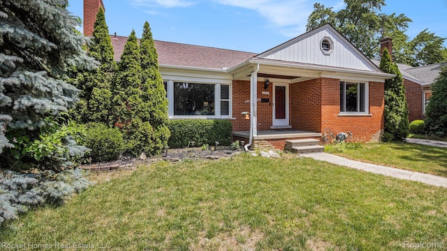 22011 Englehardt St, Saint Clair Shores, MI 48080 - view of front of home featuring brick siding, a front yard, a chimney, and a porch
