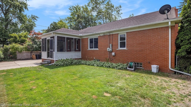 22011 Englehardt St, Saint Clair Shores, MI 48080 - rear view of house featuring a sunroom, brick siding, a chimney, and roof with shingles