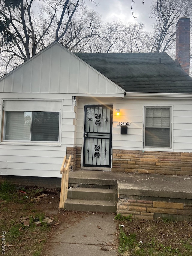 19500 Rutherford St, Detroit, MI 48235 - property entrance featuring a chimney, roof with shingles, and board and batten siding