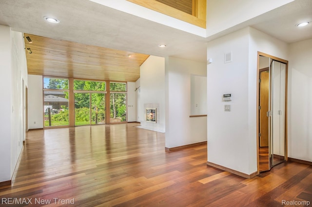 3234 Pine Lake Rd, West Bloomfield, MI 48324 - unfurnished living room featuring wood finished floors, recessed lighting, floor to ceiling windows, and a glass covered fireplace