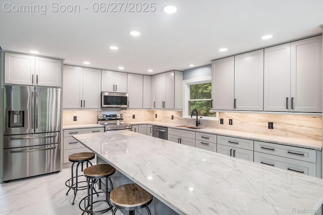 5408 N Seymour Rd, Flushing, MI 48433 - kitchen with appliances with stainless steel finishes, light marble finish floors, a kitchen bar, light stone counters, and tasteful backsplash