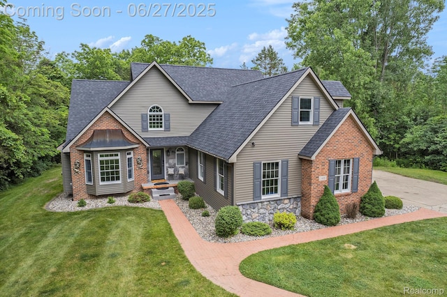5408 N Seymour Rd, Flushing, MI 48433 - view of front of home featuring a shingled roof, a front yard, stone siding, and brick siding