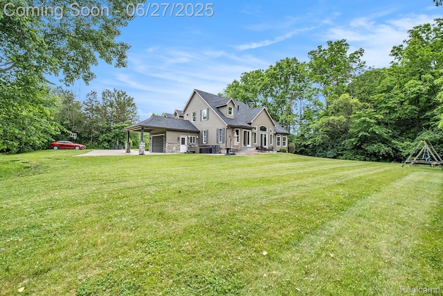 5408 N Seymour Rd, Flushing, MI 48433 - back of property with a lawn, driveway, stone siding, and a patio area